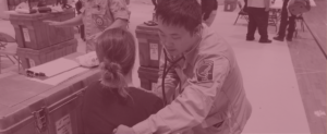 A physician with the National Disaster Medical Service examines a patient at the Silsbee High School medical site after Hurricane Harvey.